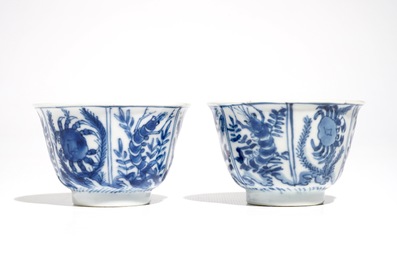 A pair of Chinese bleu and white cups and saucers with crabs and fish, Kangxi