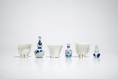 Three Chinese blanc de Chine libation cups and three blue and white miniature vases, Kangxi