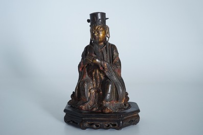 A Chinese partly gilt and polychrome bronze figure of Wenchang Dijun on wooden stand, Ming