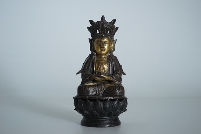 A partly gilt Chinese bronze figure of Buddha seated on a lotus throne, late Ming