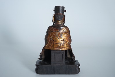 A Chinese partly gilt and polychrome bronze figure of Wenchang Dijun on wooden stand, Ming