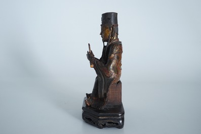 A Chinese partly gilt and polychrome bronze figure of Wenchang Dijun on wooden stand, Ming