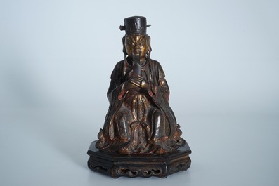 A Chinese partly gilt and polychrome bronze figure of Wenchang Dijun on wooden stand, Ming