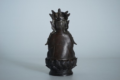 A partly gilt Chinese bronze figure of Buddha seated on a lotus throne, late Ming