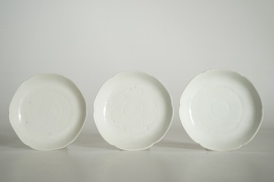 Three blanc de Chine cups and saucers with floral anhua design, Yongzheng/Qianlong