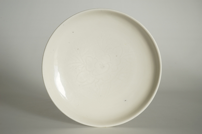 Un plat en porcelaine blanc de Chine &agrave; d&eacute;cor floral incis&eacute;, Kangxi