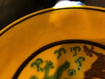 Une assiette en porcelaine de Chine &agrave; d&eacute;cor de dragons sur fond jaune, Kangxi