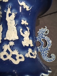 A tall Chinese blue-ground vase with applied white design, 19th C.