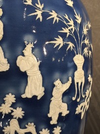 A tall Chinese blue-ground vase with applied white design, 19th C.