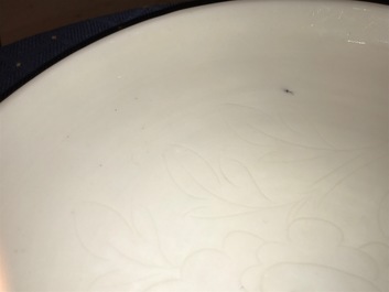 Un plat en porcelaine blanc de Chine &agrave; d&eacute;cor floral incis&eacute;, Kangxi