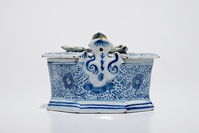 A Dutch Delft blue and white butter tub with polychrome finial, 18th C.