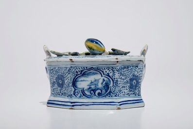 A Dutch Delft blue and white butter tub with polychrome finial, 18th C.