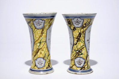 A pair of Dutch Delft polychrome beaker vases and two chargers, 18th C.
