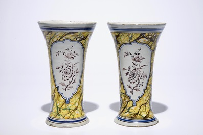 A pair of Dutch Delft polychrome beaker vases and two chargers, 18th C.