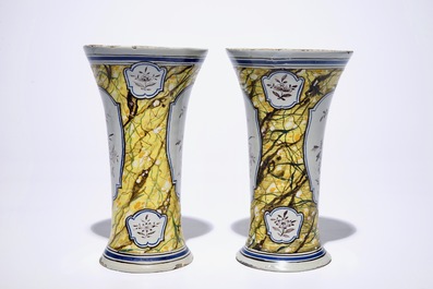 A pair of Dutch Delft polychrome beaker vases and two chargers, 18th C.