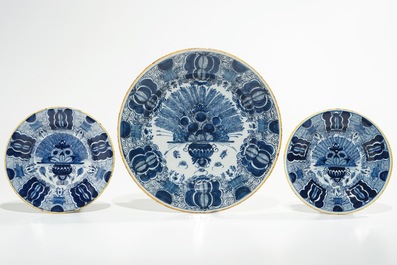Five Dutch Delft blue and white plates with dragons, tea trees and a peacock's tail, 17/18th C.
