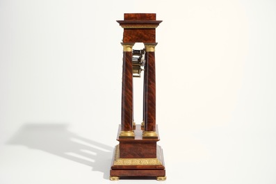 An Empire mahogany and gilt bronze portico mantle clock, France, 19th C.