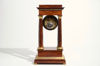 An Empire mahogany and gilt bronze portico mantle clock, France, 19th C.