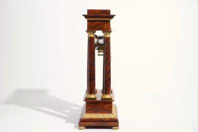 An Empire mahogany and gilt bronze portico mantle clock, France, 19th C.