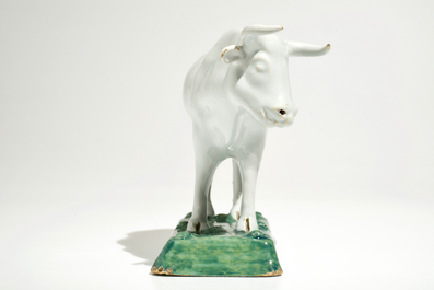 A white Dutch Delft model of a cow on a green base, 18th C.