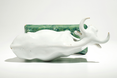 A white Dutch Delft model of a cow on a green base, 18th C.