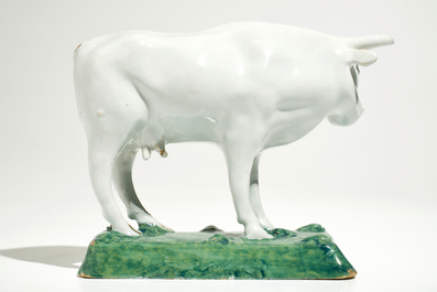 A white Dutch Delft model of a cow on a green base, 18th C.
