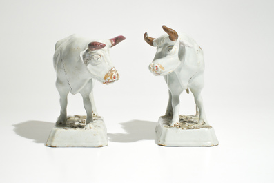 A pair of large cold-painted white Dutch Delft cows on bases, 18th C.