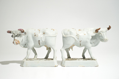 A pair of large cold-painted white Dutch Delft cows on bases, 18th C.