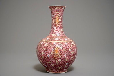 Un vase de forme bouteille en porcelaine de Chine famille rose sur fond rouge rubis, marque de Qianlong, 19/20&egrave;me