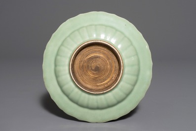 Een Chinees celadon bord met onderglazuur decor van een lotus, Qianlong