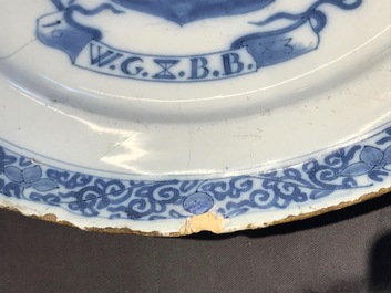 A Dutch Delft blue and white armorial dish dated 1683 and a blue and white landscape plate, 17th C.