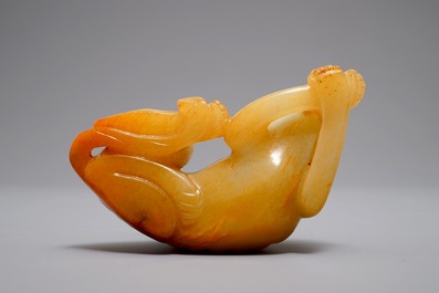 A Chinese carved russet jade model of a reclining dog, 19/20th C.