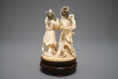 A Chinese carved ivory group of two ladies near an altar table, 1st half 20th C.