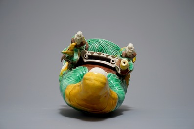 A Chinese verte biscuit group of Guanyin on a lotus throne, 18th C.