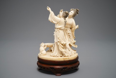 A Chinese carved ivory group of two ladies near an altar table, 1st half 20th C.