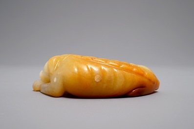 A Chinese carved russet jade model of a reclining dog, 19/20th C.