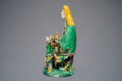 A Chinese verte biscuit group of Guanyin on a lotus throne, 18th C.