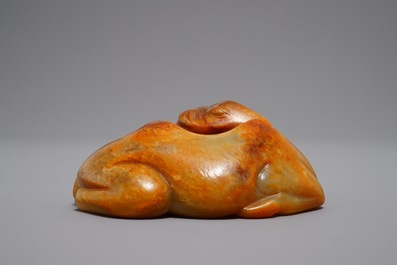 A Chinese carved russet jade model of a reclining horse, 19/20th C.