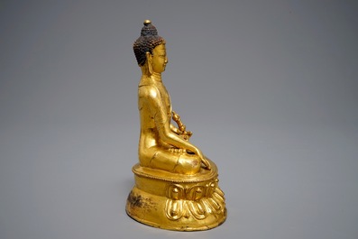 A Tibetan gilt bronze figure of Buddha with vajra, 19th C.