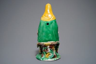 A Chinese verte biscuit group of Guanyin on a lotus throne, 18th C.