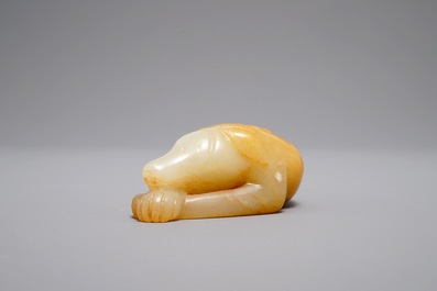 A Chinese carved russet jade model of a reclining dog, 19/20th C.