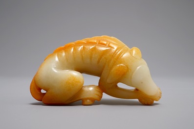 Een Chinees model van een liggende hond in gevlekte jade, 19/20e eeuw