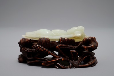 A Chinese celadon jade model of a reclining lady on lotus leaf, Qing
