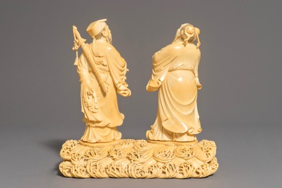 A Chinese carved ivory group of two figures on a ground, 18/19th C.