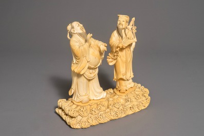 A Chinese carved ivory group of two figures on a ground, 18/19th C.