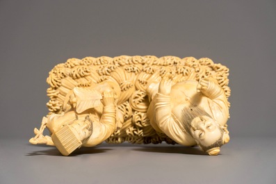 A Chinese carved ivory group of two figures on a ground, 18/19th C.