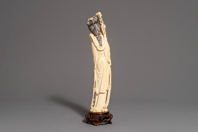 Een Chinese ivoren figuur van een dame op houten sokkel, 2e helft 19e eeuw