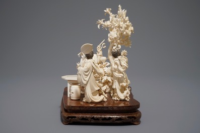 A Chinese carved ivory group on inlaid wooden base, 1st half 20th C.