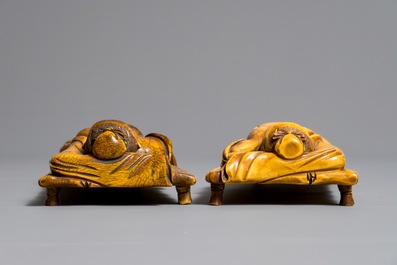 A pair of Chinese carved ivory figures of resting men on a bed, 19th C.