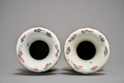 A pair of Chinese famille rose vases with figures in an interior, 19th C.